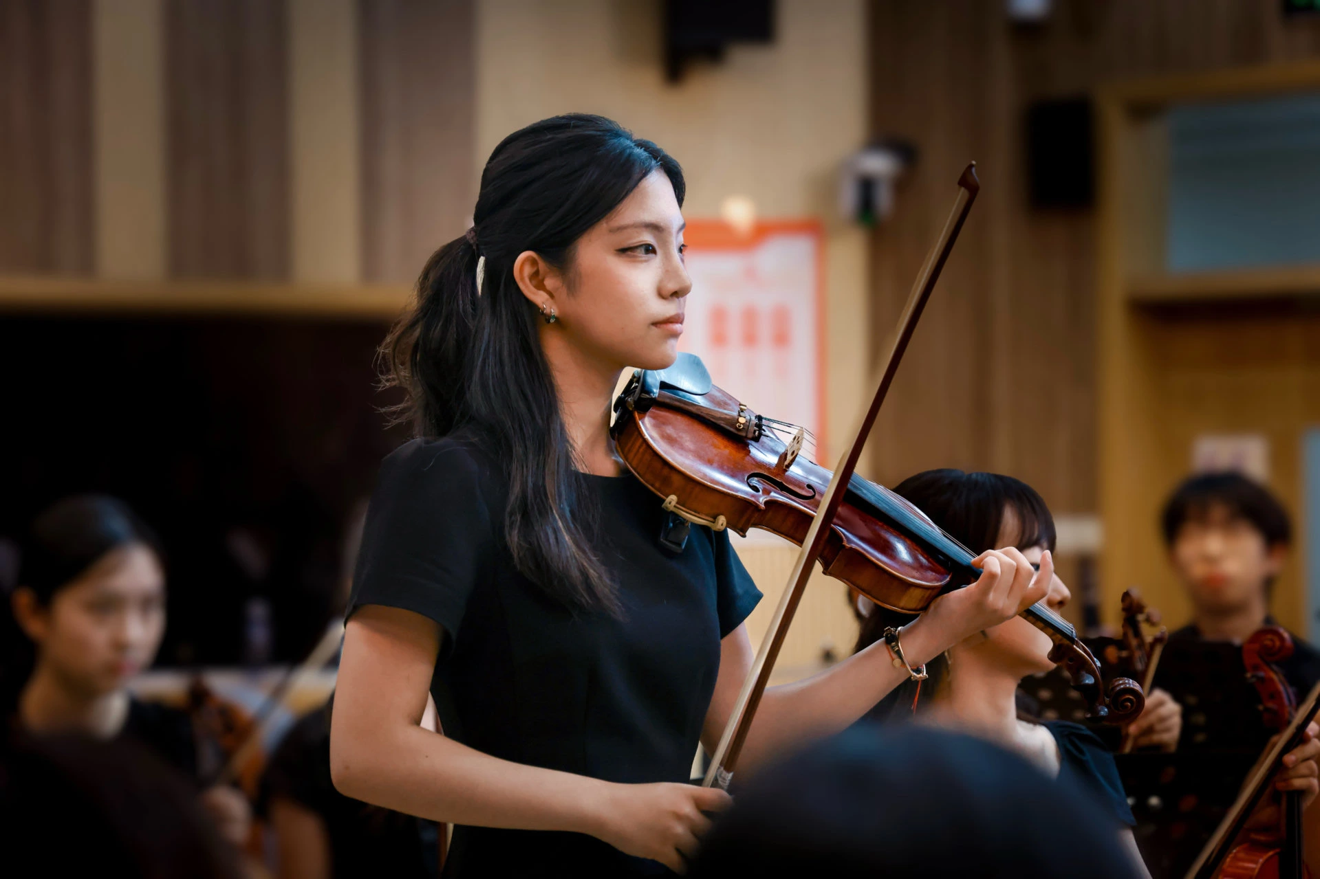 Jenny playing violin with an orchestra